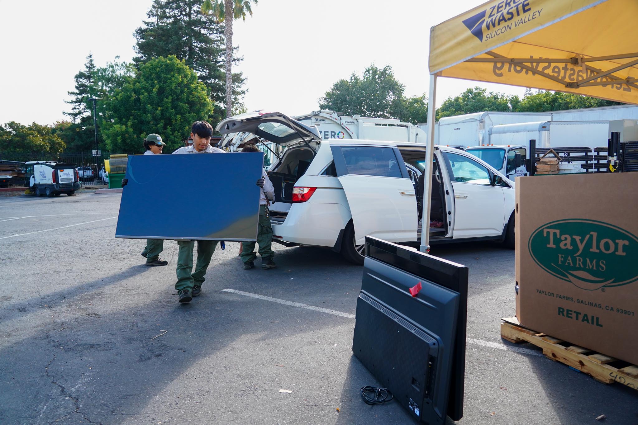Corpmember carrying television from a white van